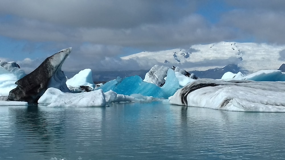 snow covered mountain near body of water during daytime