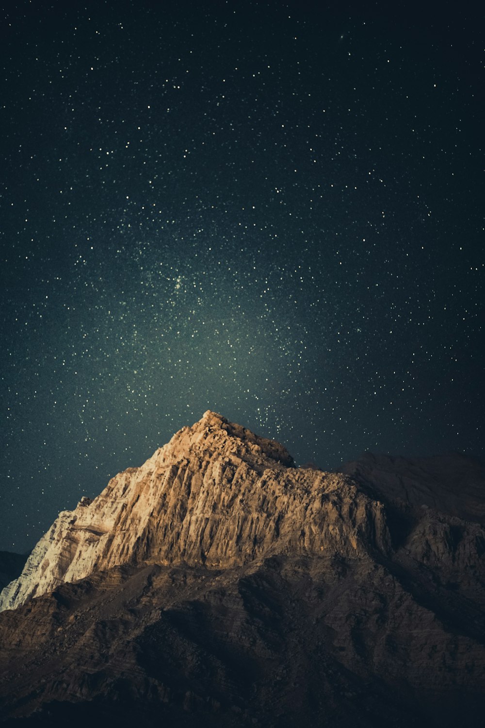 brown rocky mountain under starry night