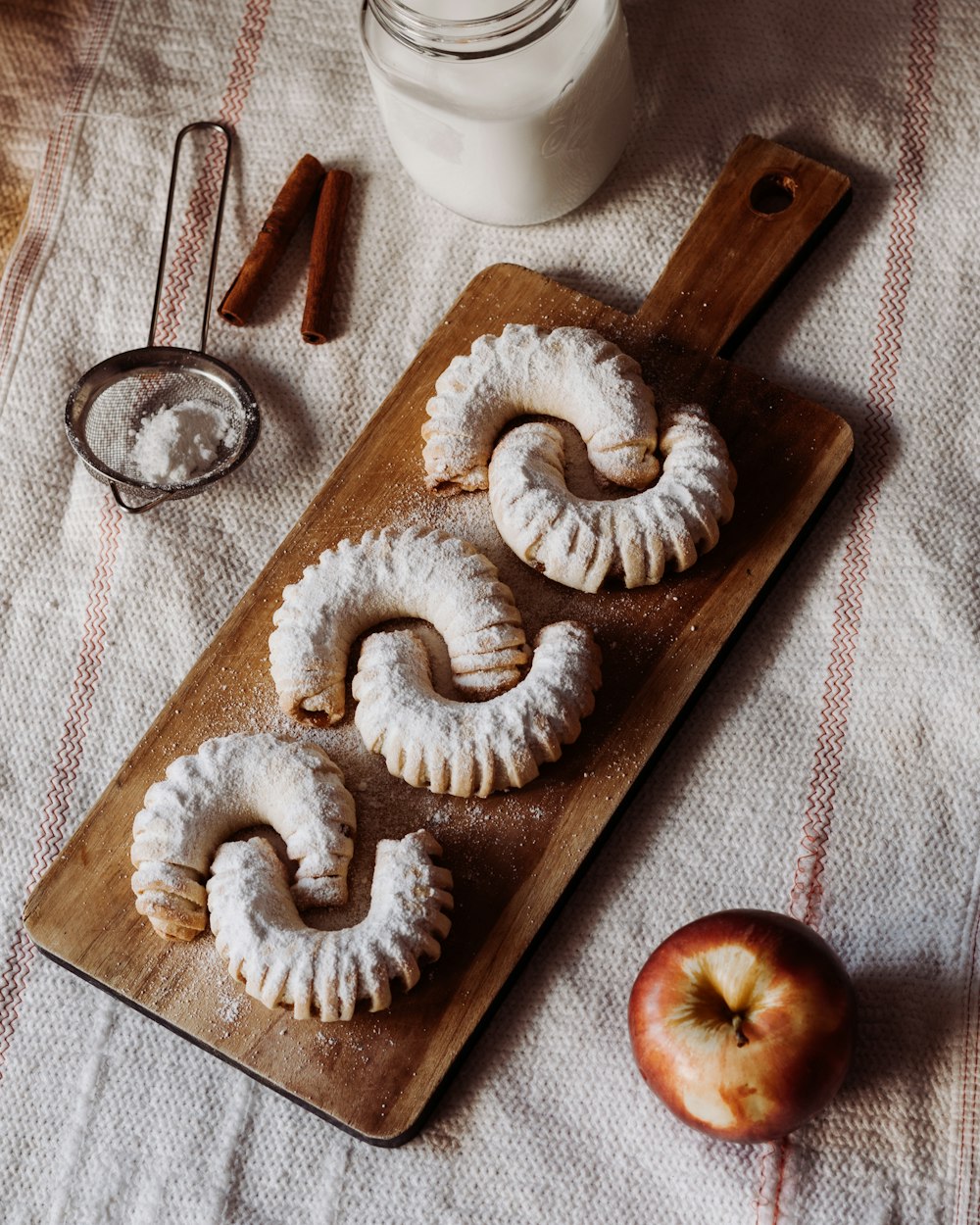 white and brown doughnut on brown wooden chopping board