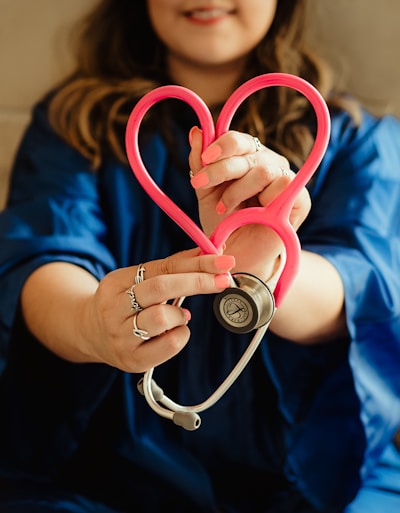 girl in blue jacket holding red and silver ring