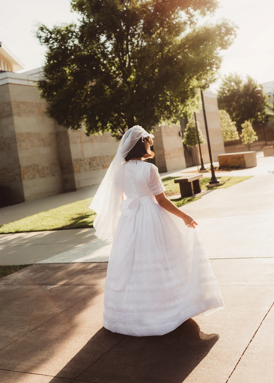 Niña de espaldas con vestido blanco de primera comunión