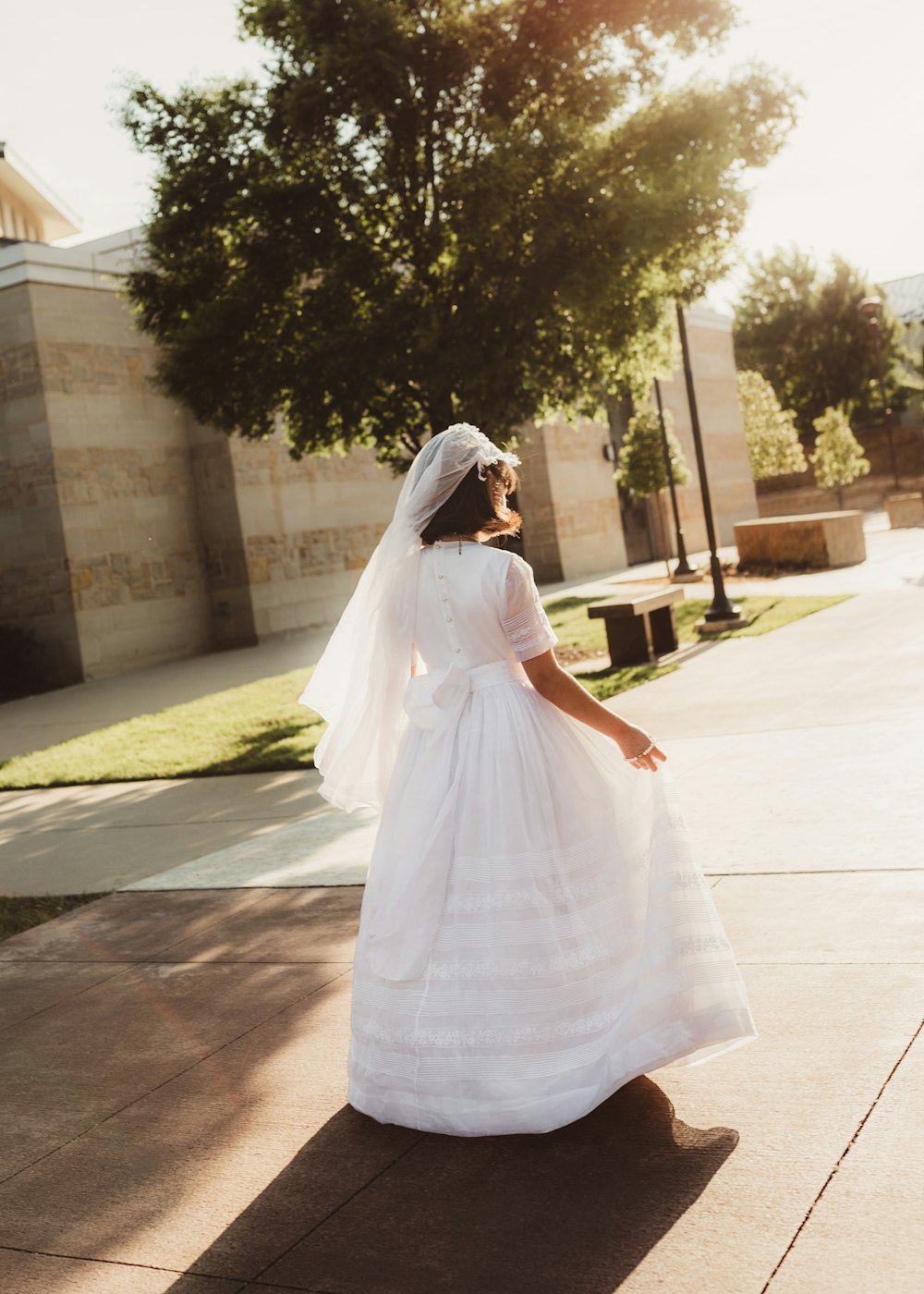 woman in white dress walking on sidewalk during daytime