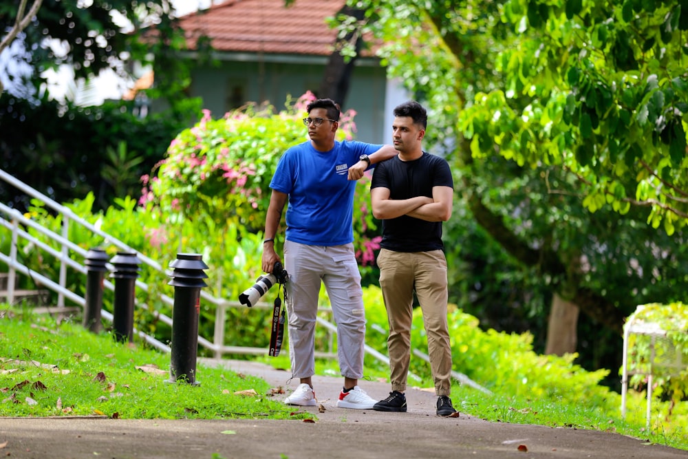 man in blue crew neck t-shirt and brown pants holding a boy in blue t