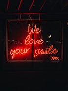 a neon sign that says we love your smile