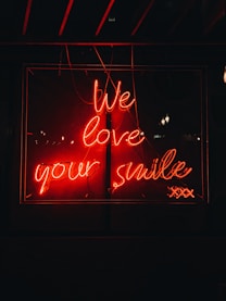 a neon sign that says we love your smile