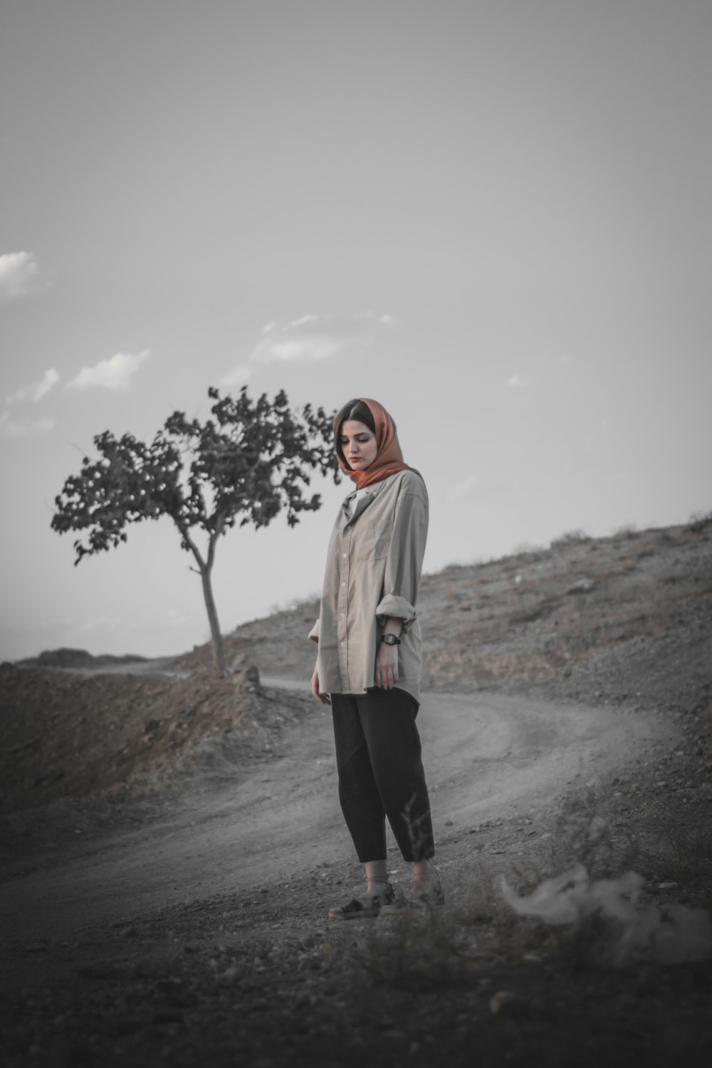 woman in white jacket and black pants standing on road during daytime