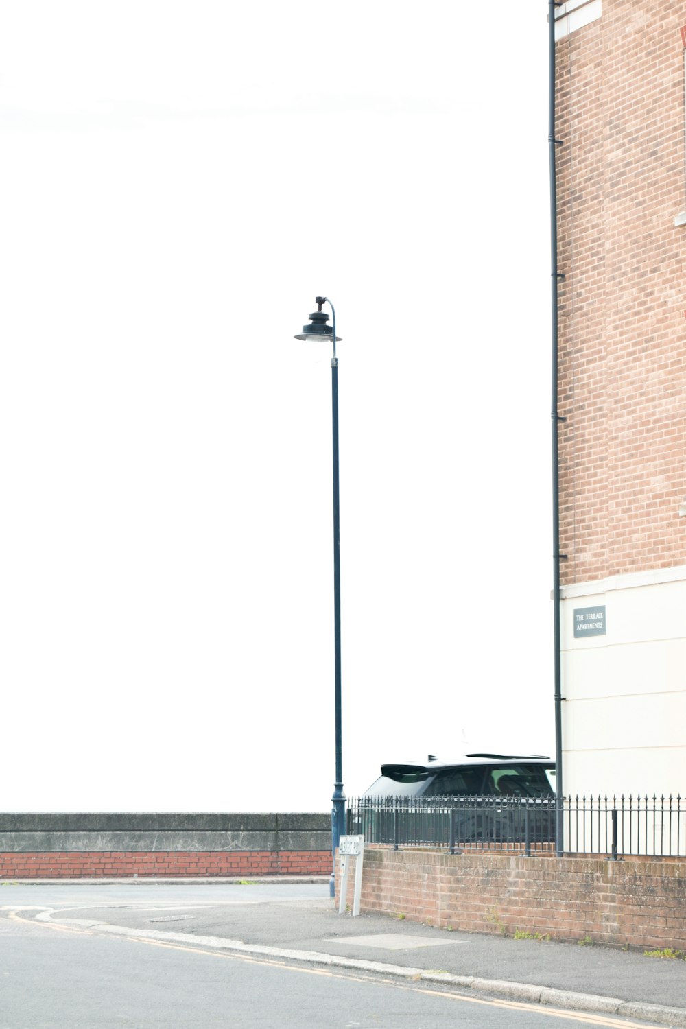 white car parked beside brown brick building