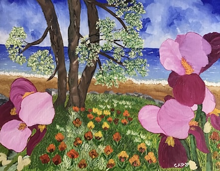 A vibrant landscape painting featuring tall trees with green foliage near a beach. Bright pink and purple flowers dominate the foreground with lush green grass and smaller orange and yellow flowers scattered throughout. The background showcases a sandy beach leading to a blue body of water under a cloudy sky.