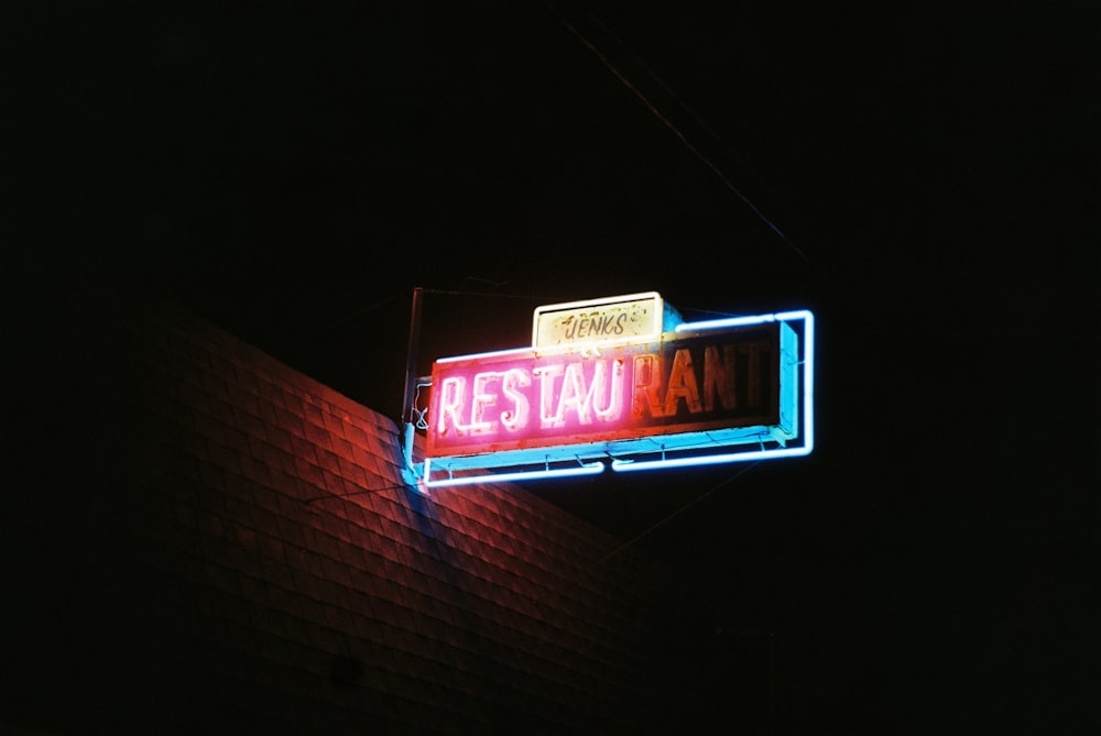 a neon sign hanging from the side of a building