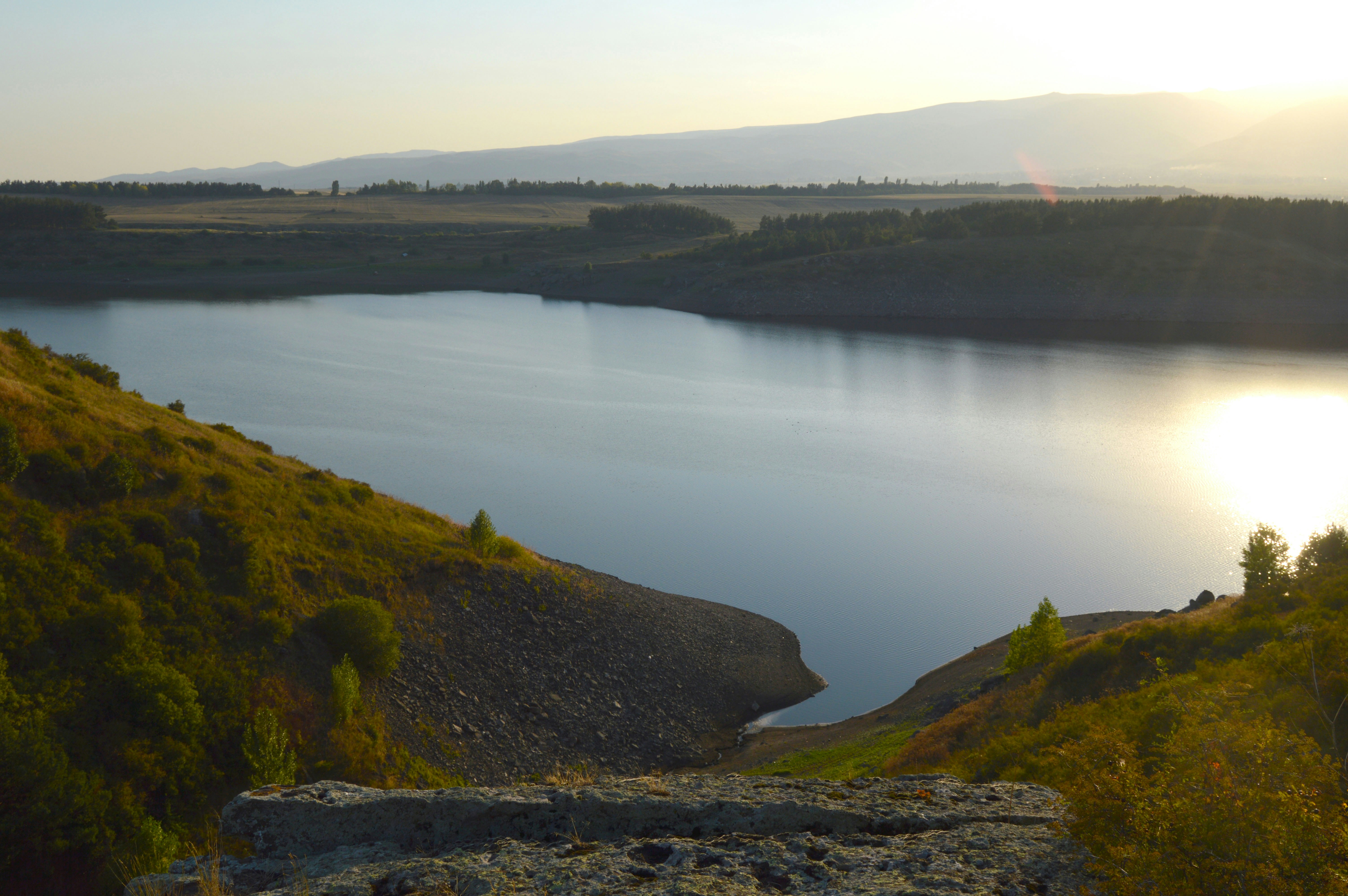 green mountain beside body of water during daytime