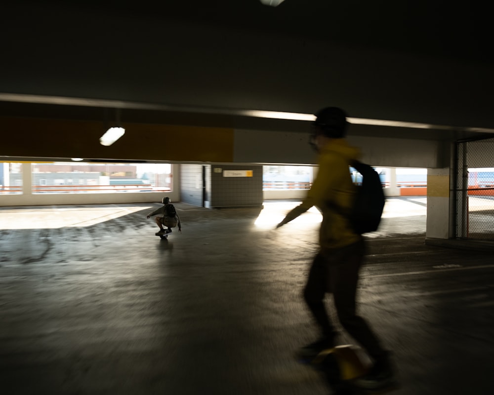 man in yellow t-shirt and black pants walking on gray floor