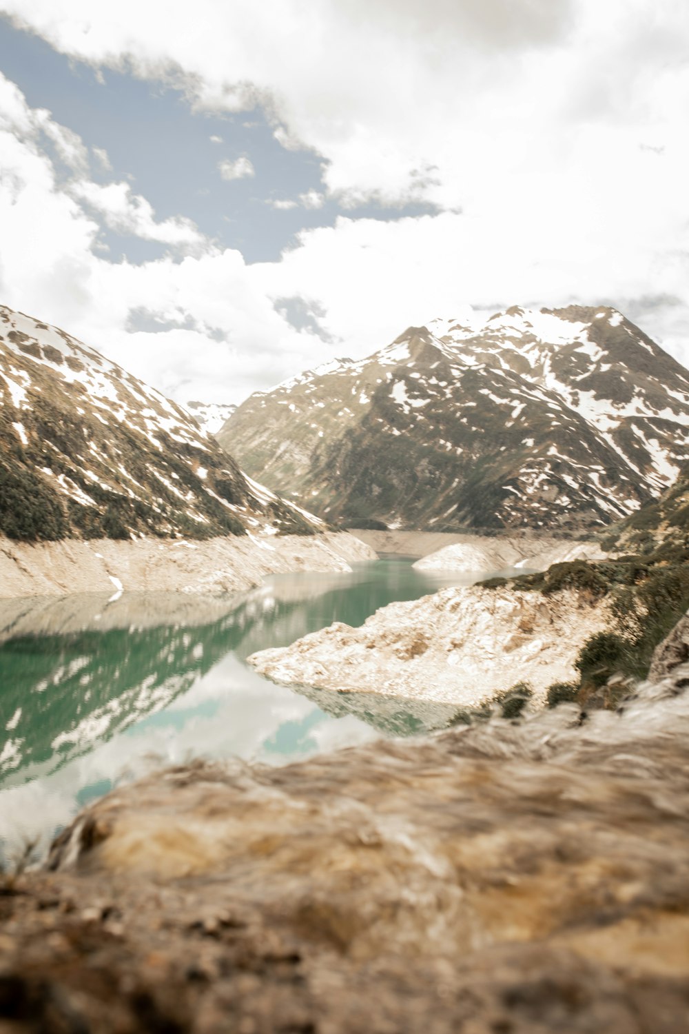 body of water near snow covered mountain during daytime