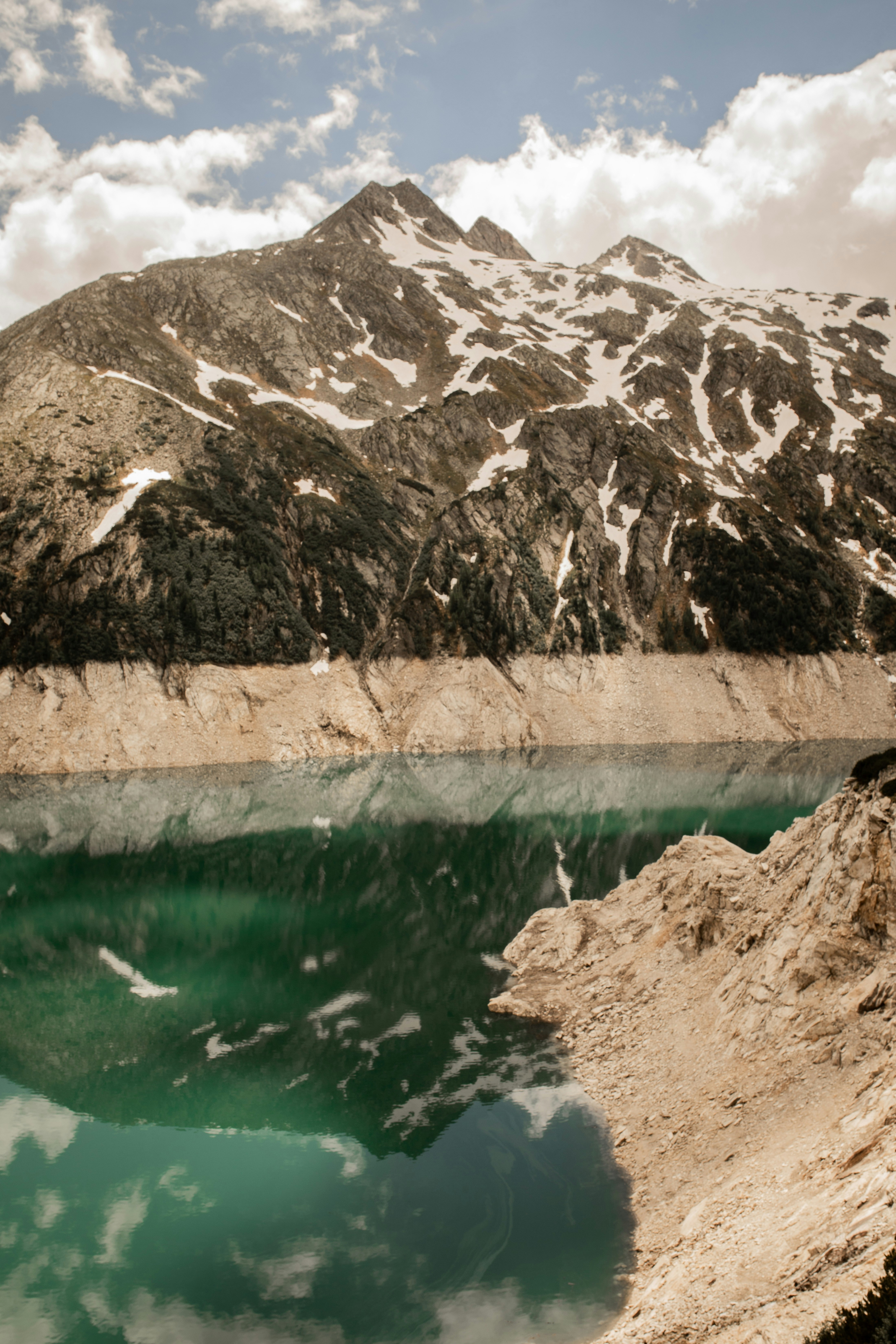 brown rock formation beside body of water during daytime