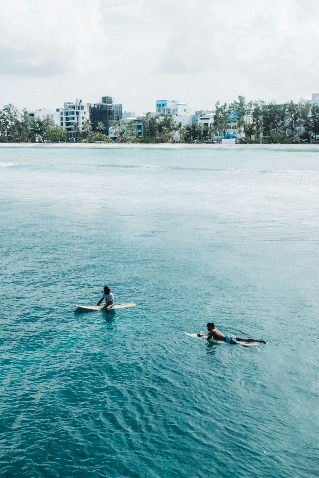 2 people surfing on sea during daytime