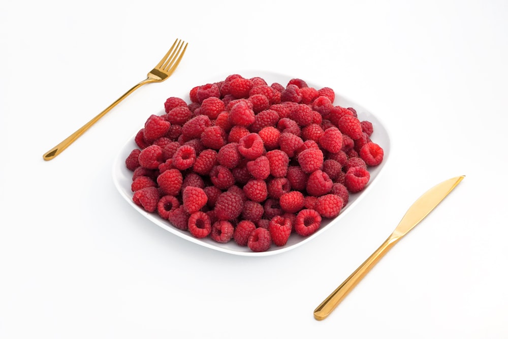red raspberries on white ceramic plate