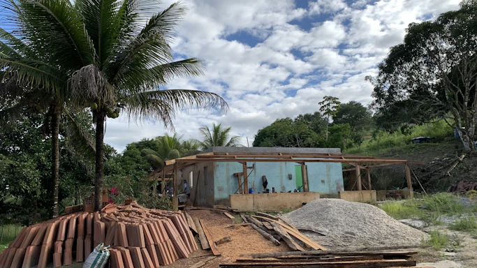 Aurorel Solutions engineer reviewing blueprints on site with Caribbean landscape in the background.