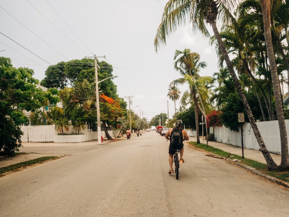 man in black jacket riding bicycle on road during daytime