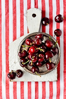 red cherries on brown ceramic bowl
