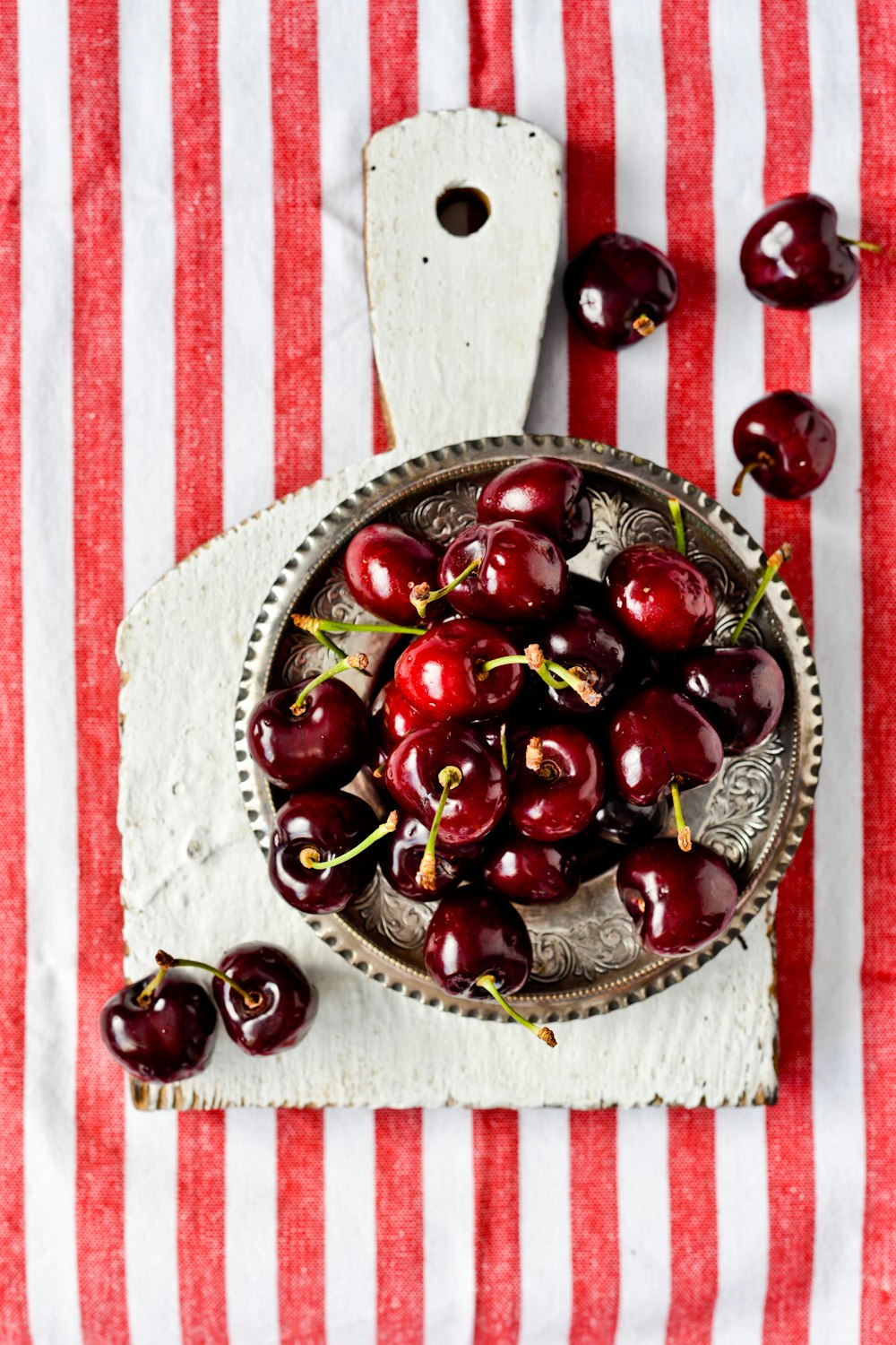 cerises rouges sur bol en céramique brune