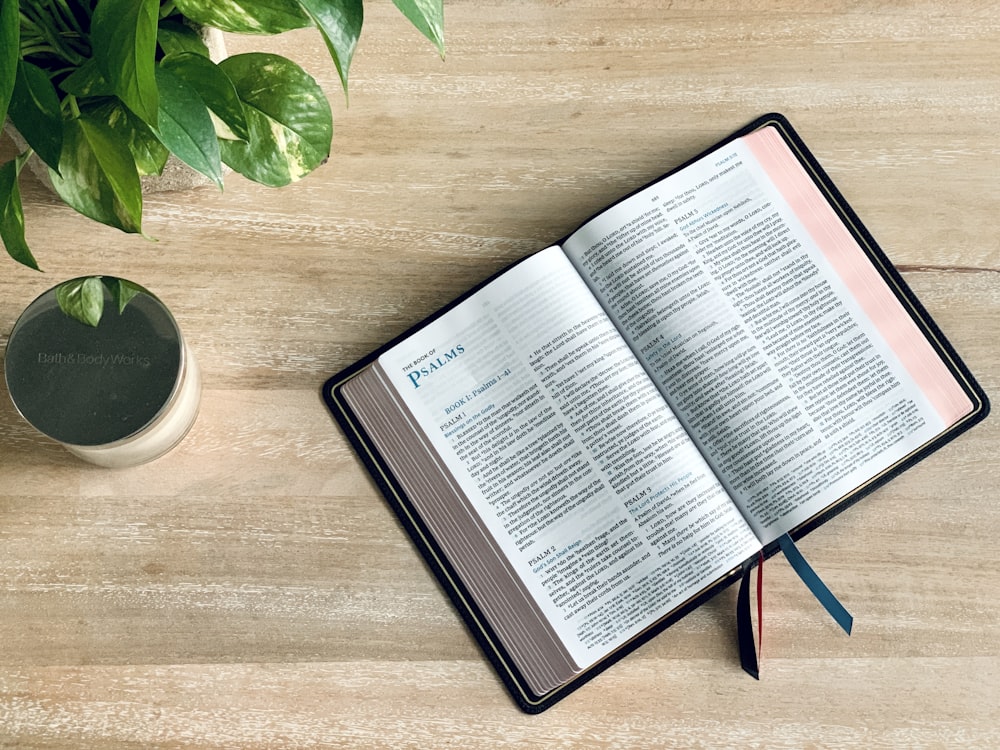 opened book on brown wooden table