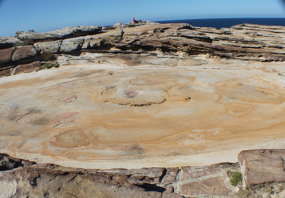 person standing on brown rock formation during daytime