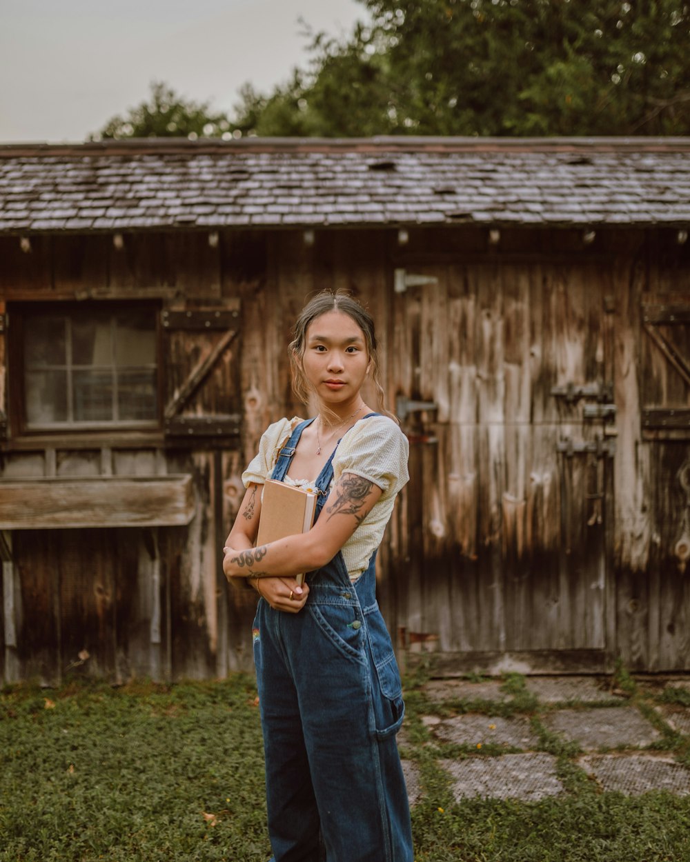 woman in blue denim jeans standing near brown wooden house during daytime  photo – Free Pants Image on Unsplash