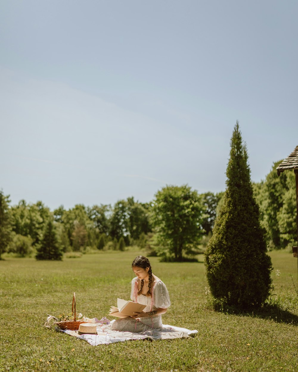 woman in white dress sitting on green grass field during daytime