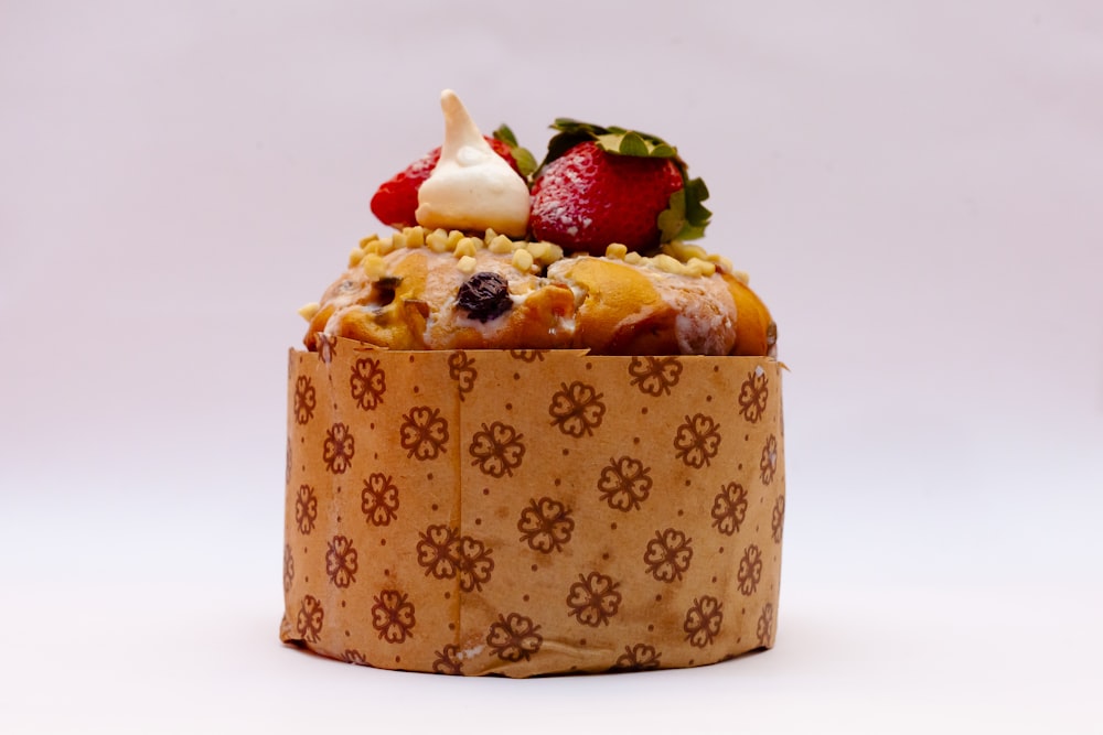 brown and white cake with strawberry on top