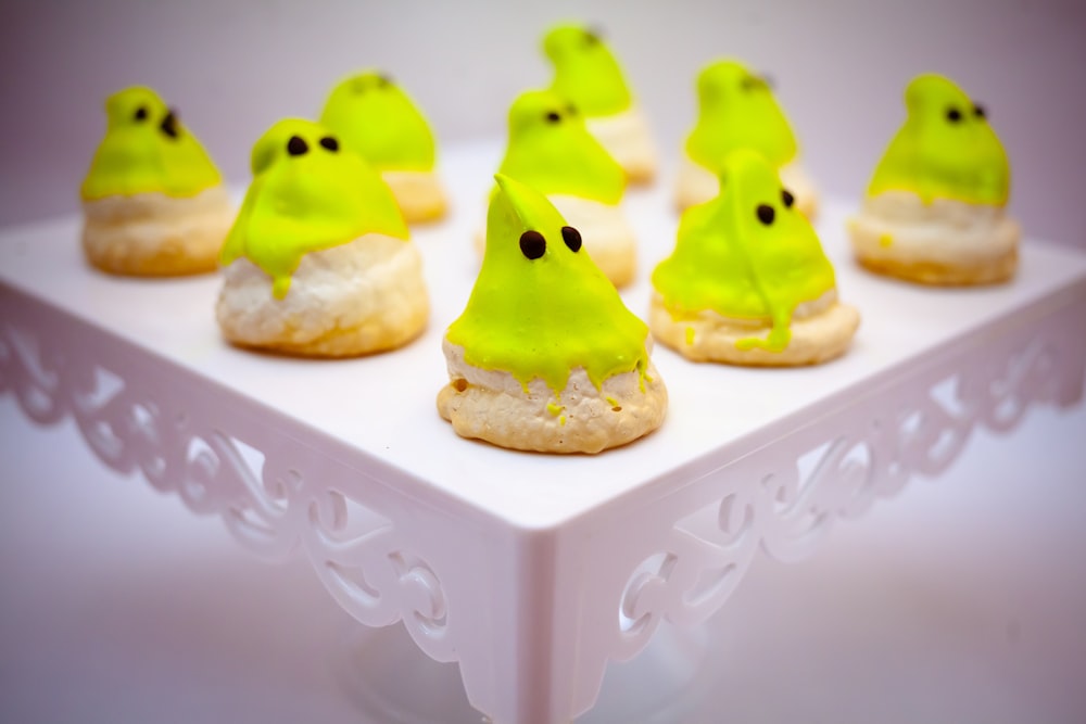 three yellow and green cupcake on white ceramic tray