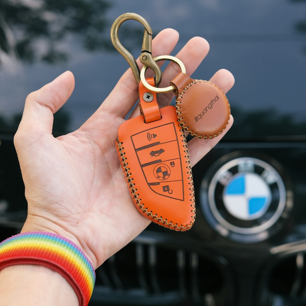 person holding brown and blue keychain