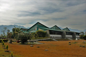 Exterior view of a modern building in Norgate with lush landscaping and mountain backdrop.