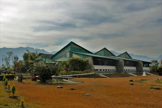 Exterior view of a modern building in Norgate with lush landscaping and mountain backdrop.