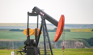 black and orange metal machine on green grass field during daytime