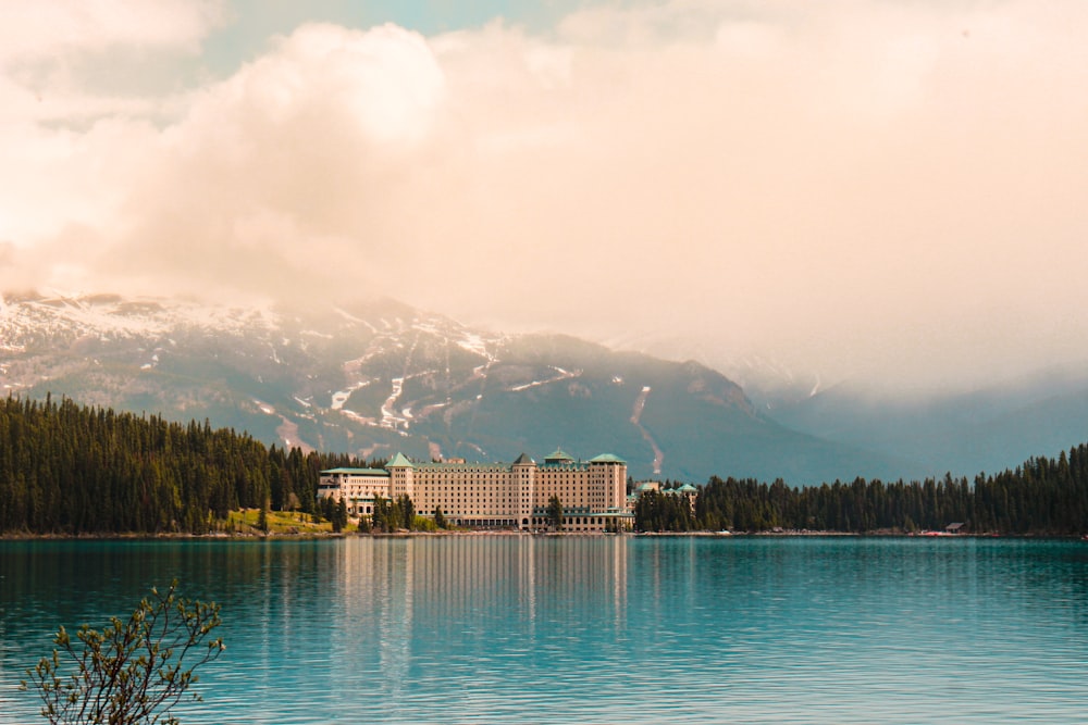 white and brown building near body of water under white clouds during daytime