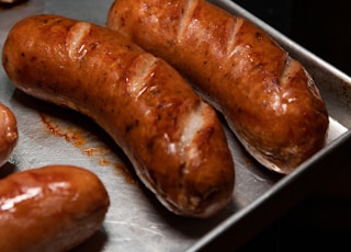 brown sausage on stainless steel tray