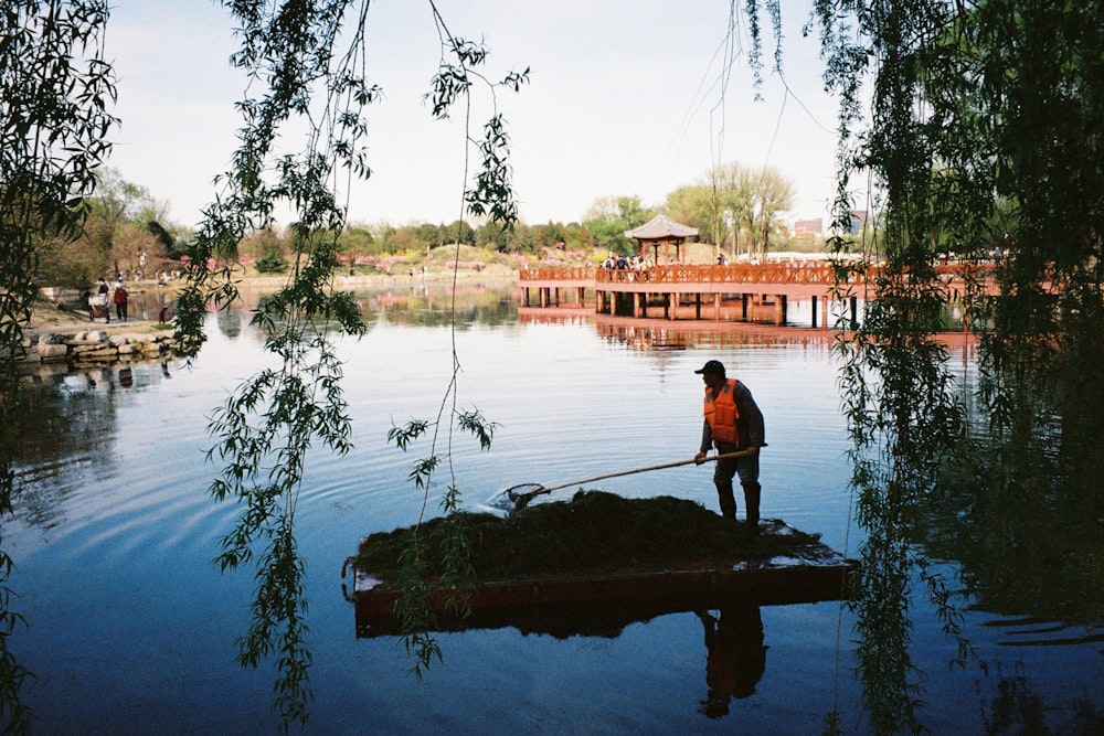man in black shirt and black pants fishing on lake during daytime