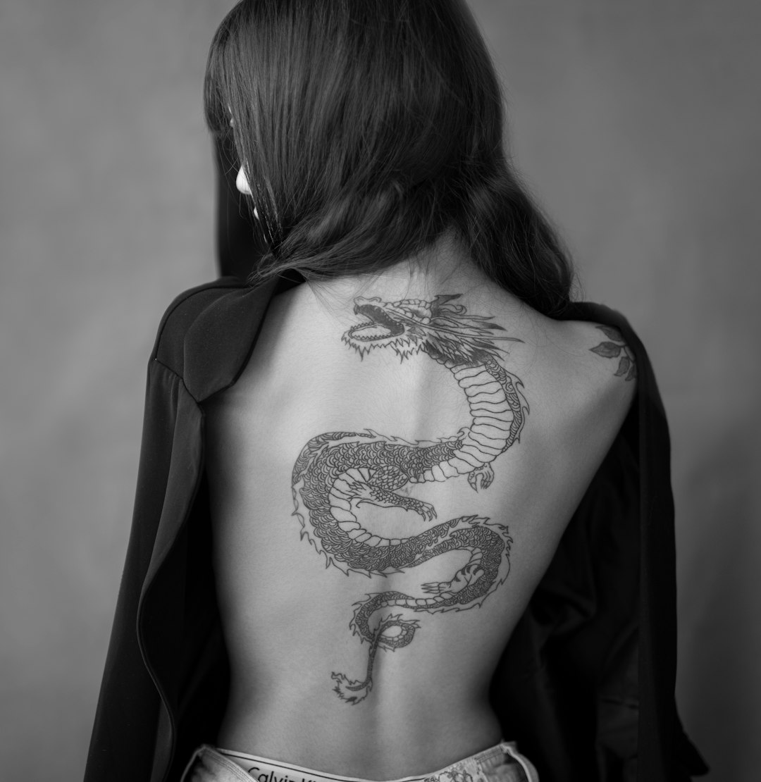 woman with black and white skull tattoo on her back
