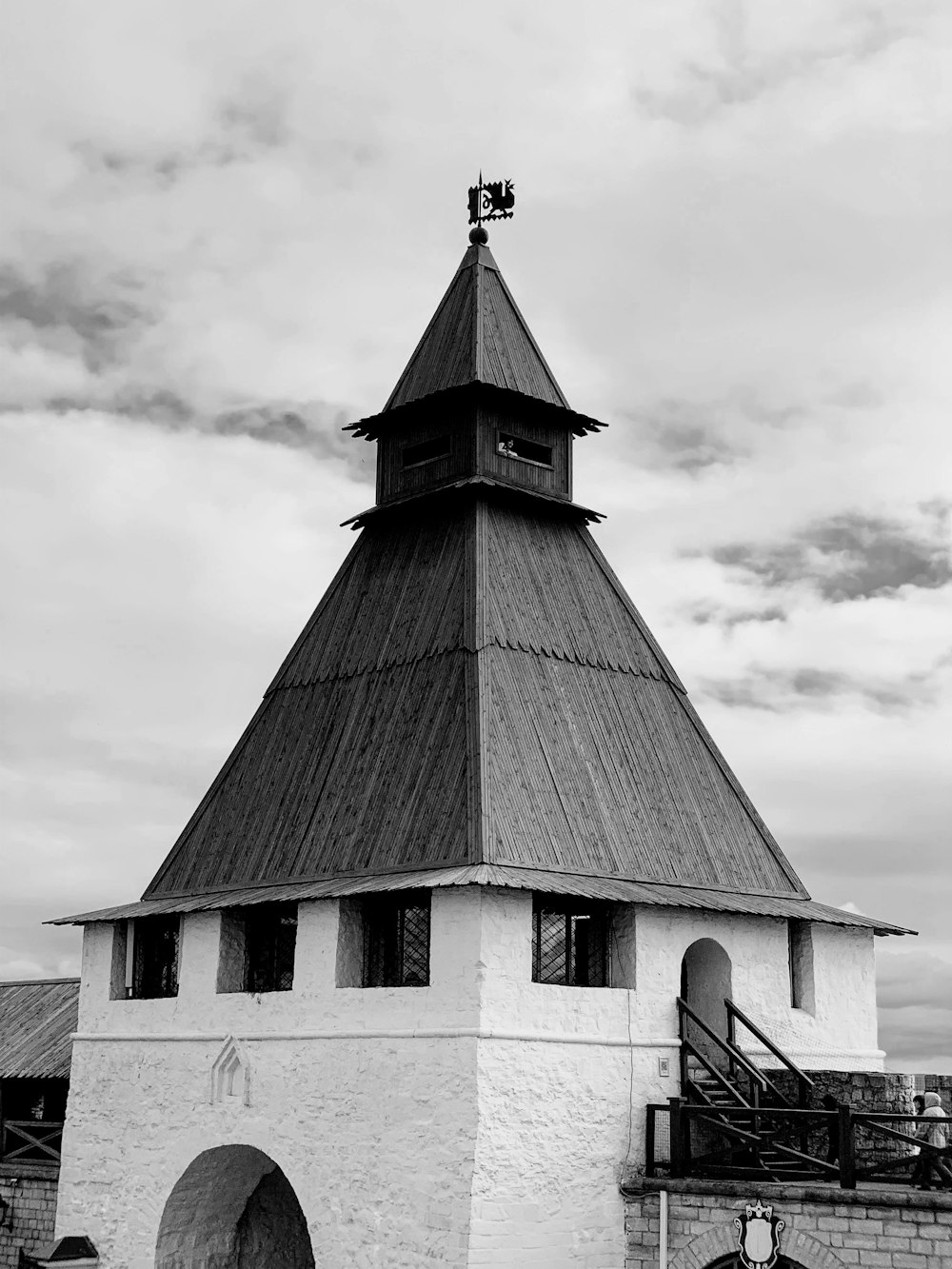 grayscale photo of church under cloudy sky