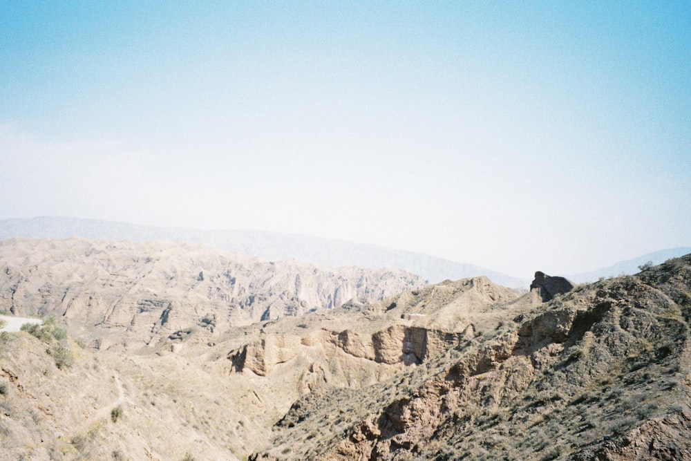 person in black jacket standing on brown rock formation during daytime