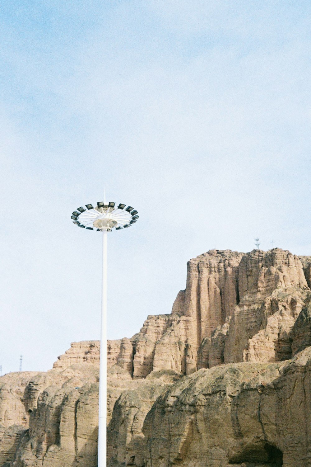 white and black satellite on top of brown rock formation during daytime