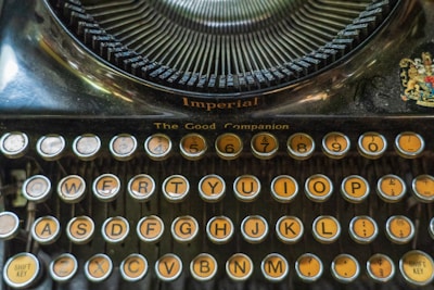 A vintage typewriter featuring round keys with yellowish backgrounds and black letters. The top section displays the brand name 'Imperial' and the model 'The Good Companion'. The keyboard layout is typical with keys arranged in a QWERTY format.