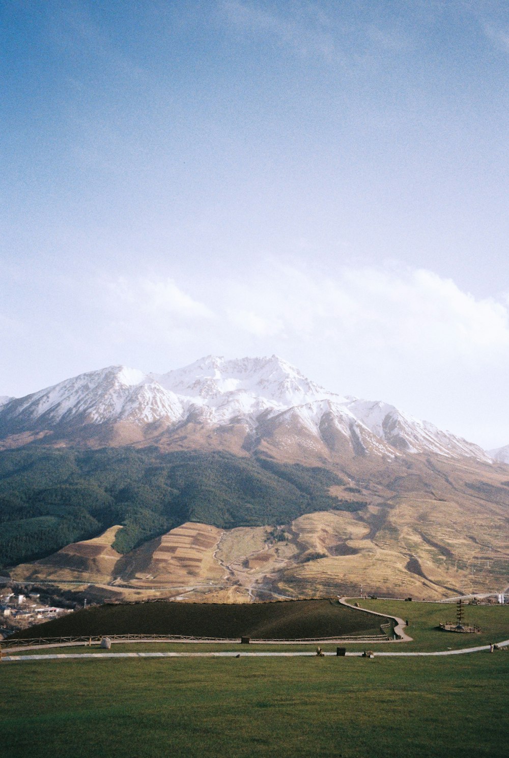 brown and green mountains under white clouds and blue sky during daytime