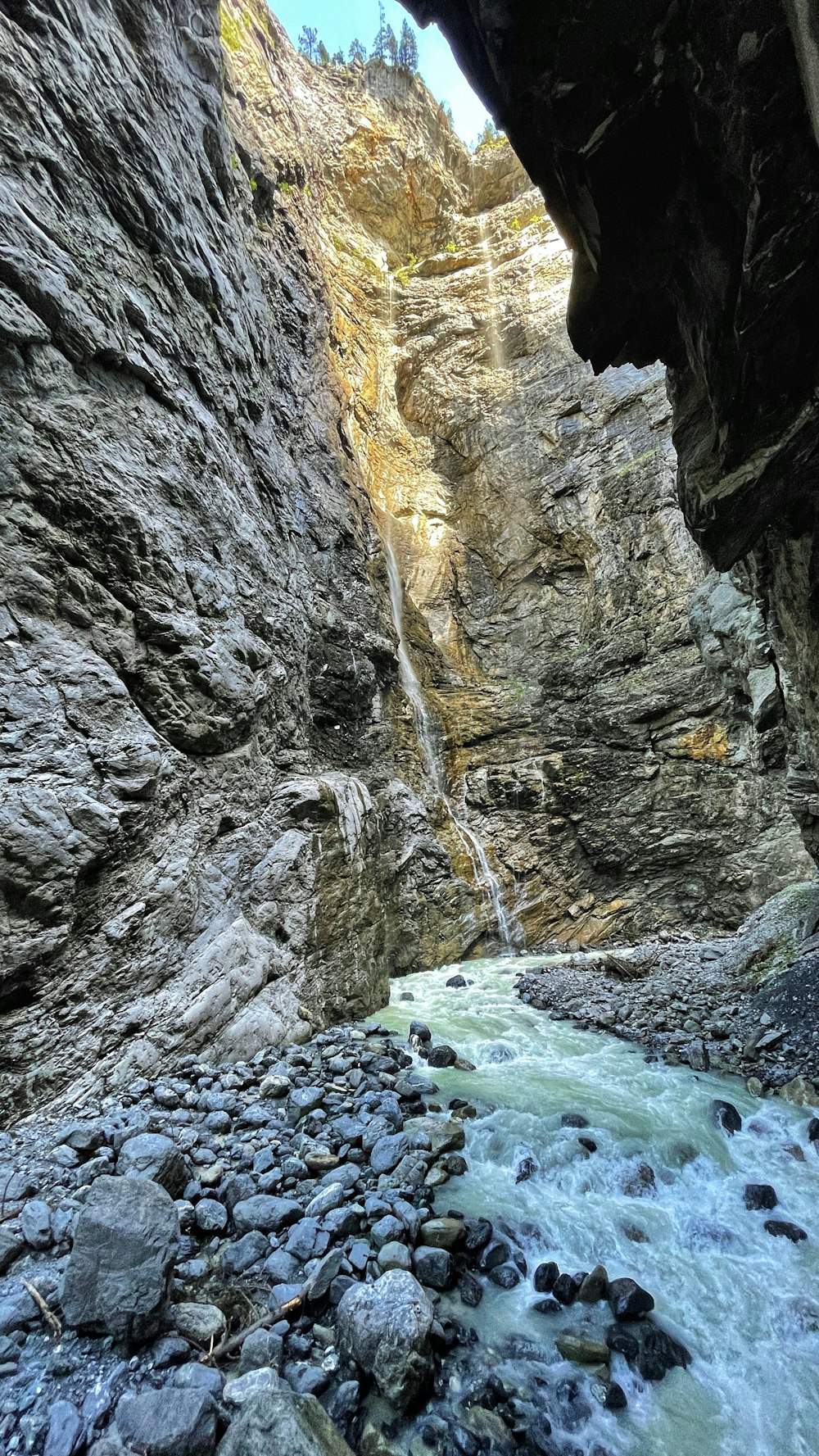 Grauer felsiger Berg mit Wasserfällen