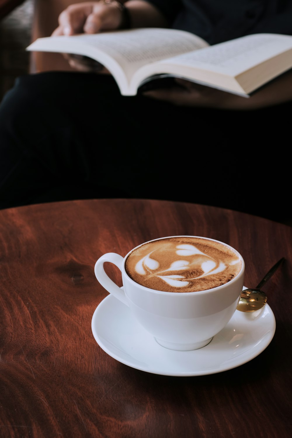 white ceramic cup with saucer on brown wooden table