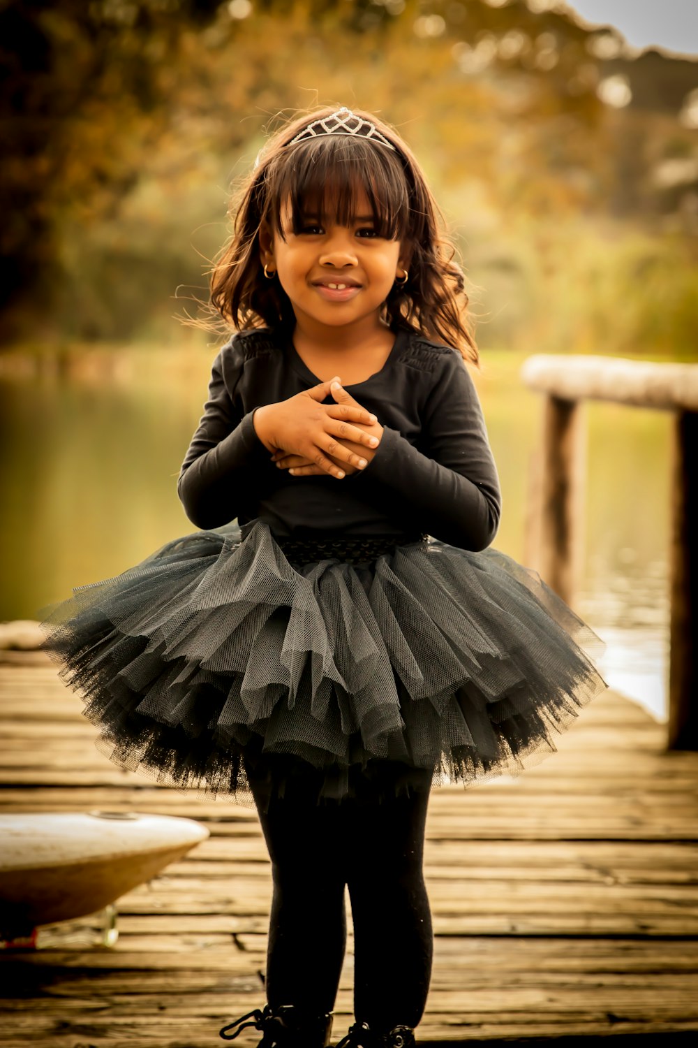 woman in black long sleeve dress sitting on wooden dock