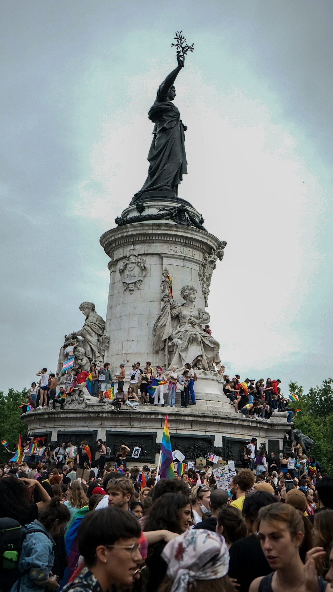 people standing on gray concrete statue under white clouds during daytime