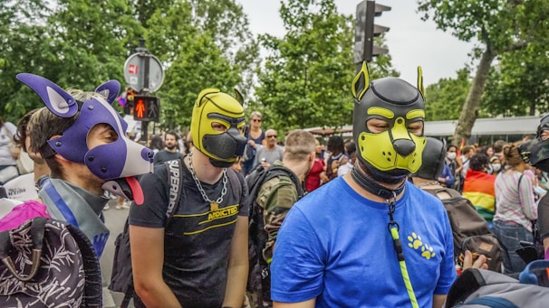 A group of smiling community members walking through a park with a friendly cat mascot.