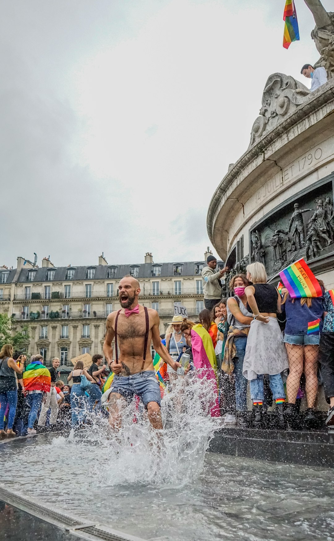 people in blue and white shorts standing on water fountain during daytime