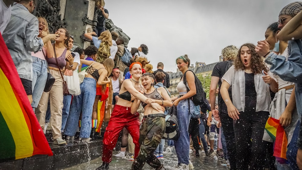 group of people standing on wet ground during daytime