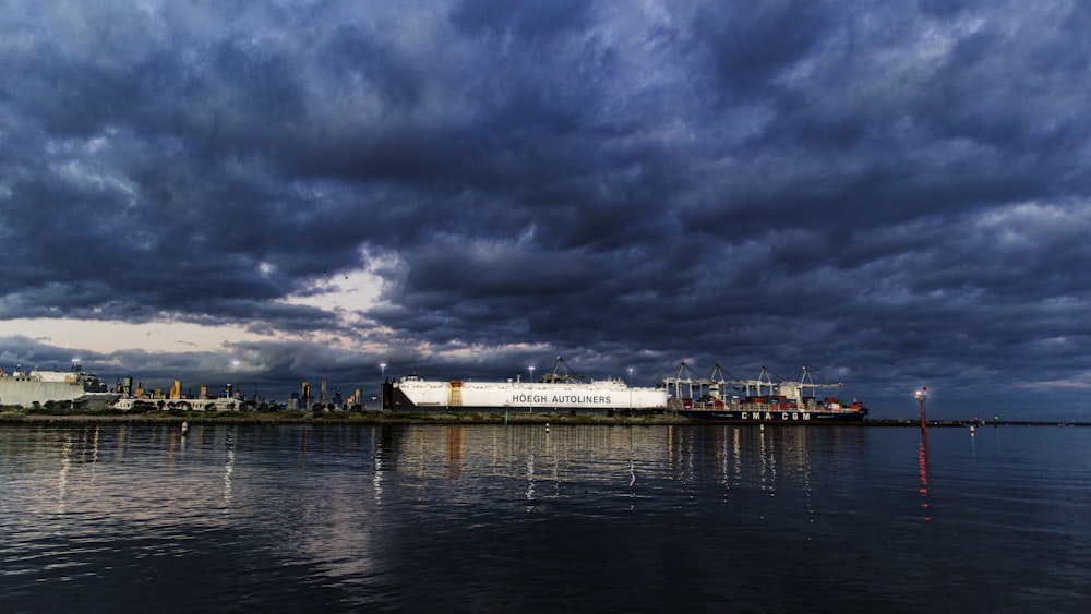 white and brown ship on sea under gray clouds